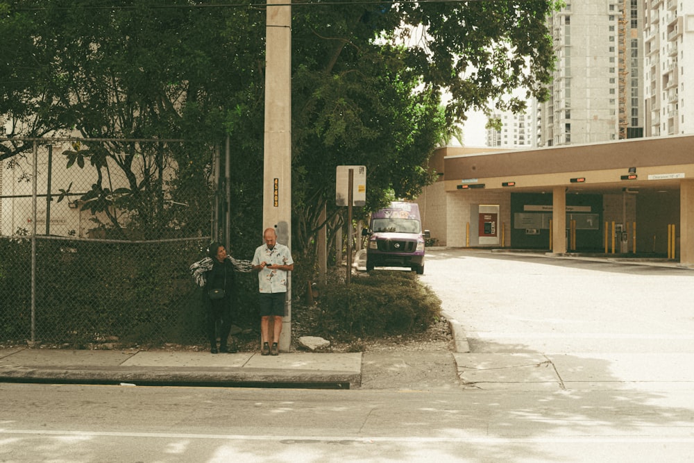 a couple of people standing next to a tall pole