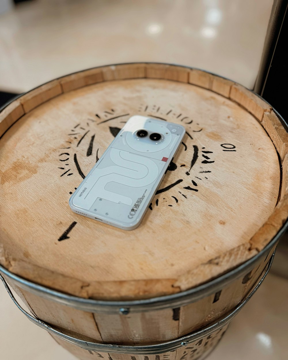 a cell phone sitting on top of a wooden barrel
