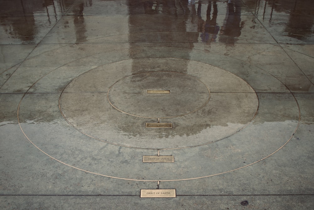 a group of people standing around a circle on a sidewalk