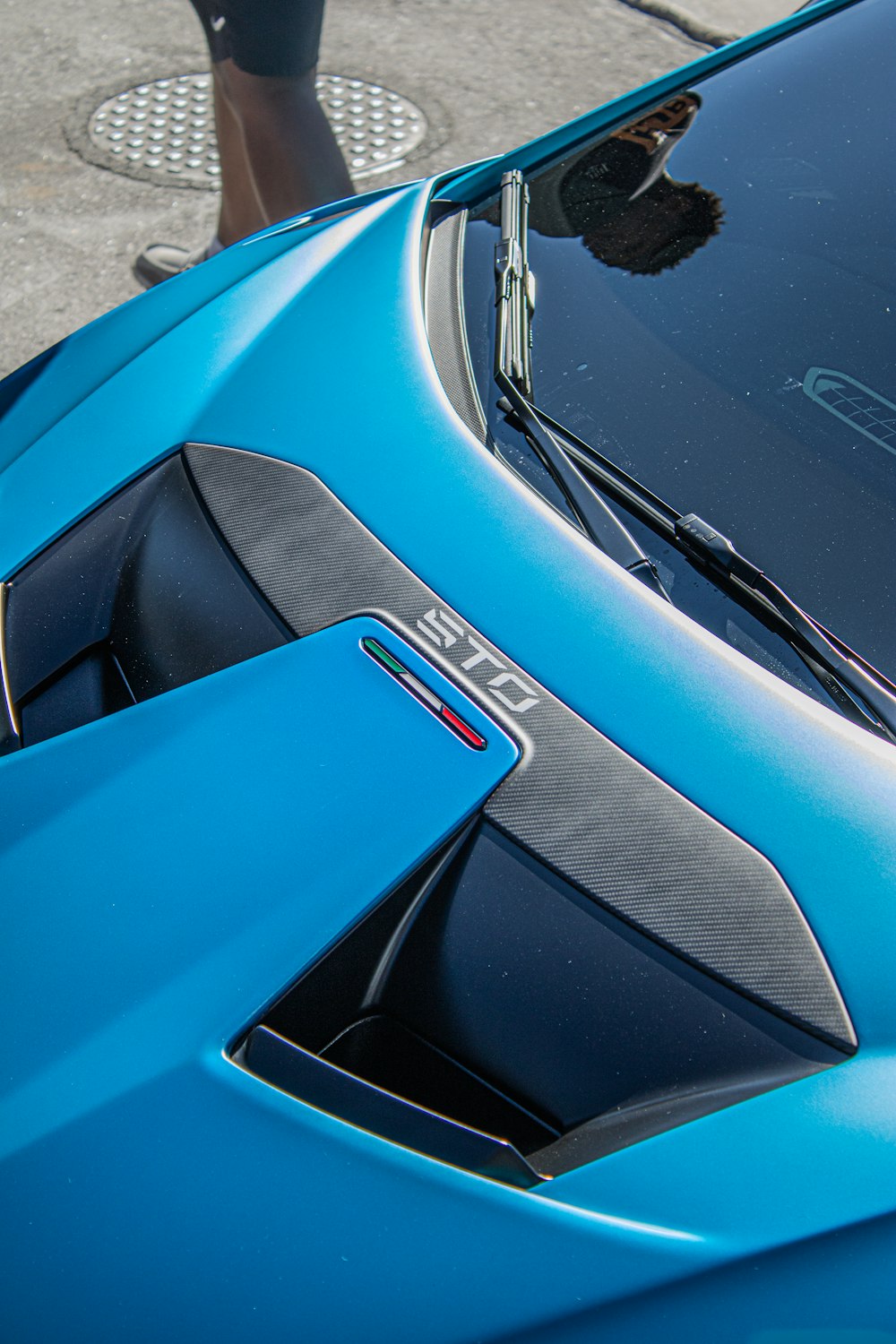 a close up of the hood of a blue sports car