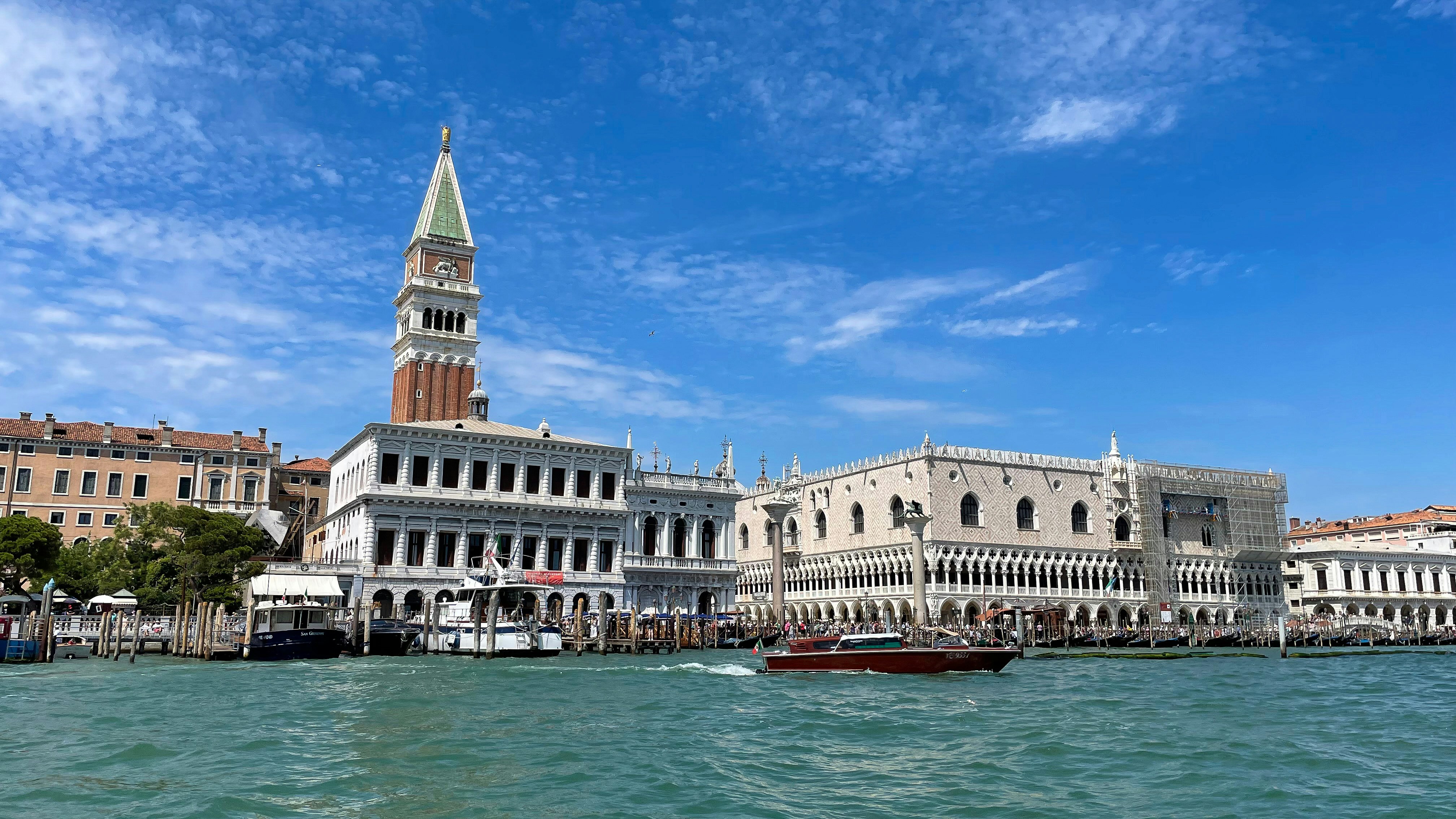a boat traveling down a river next to a tall building