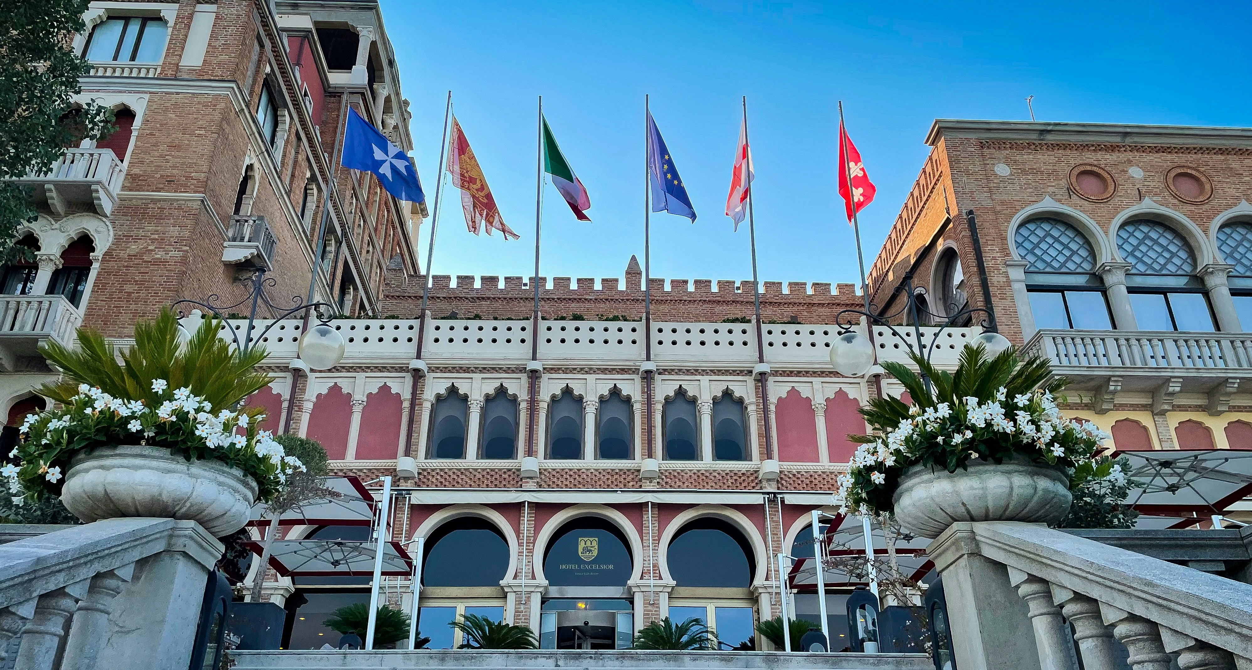 a group of flags flying in front of a building