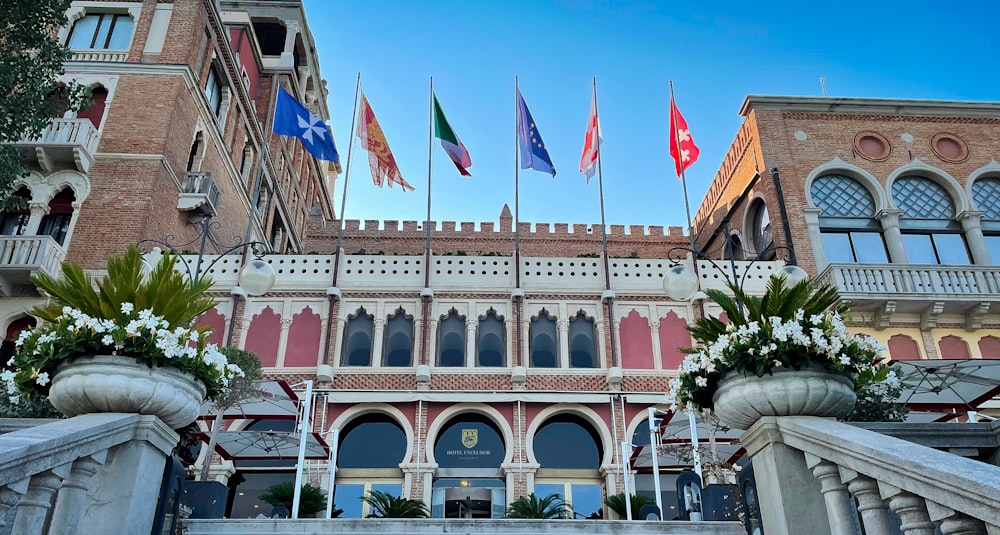 a group of flags flying in front of a building