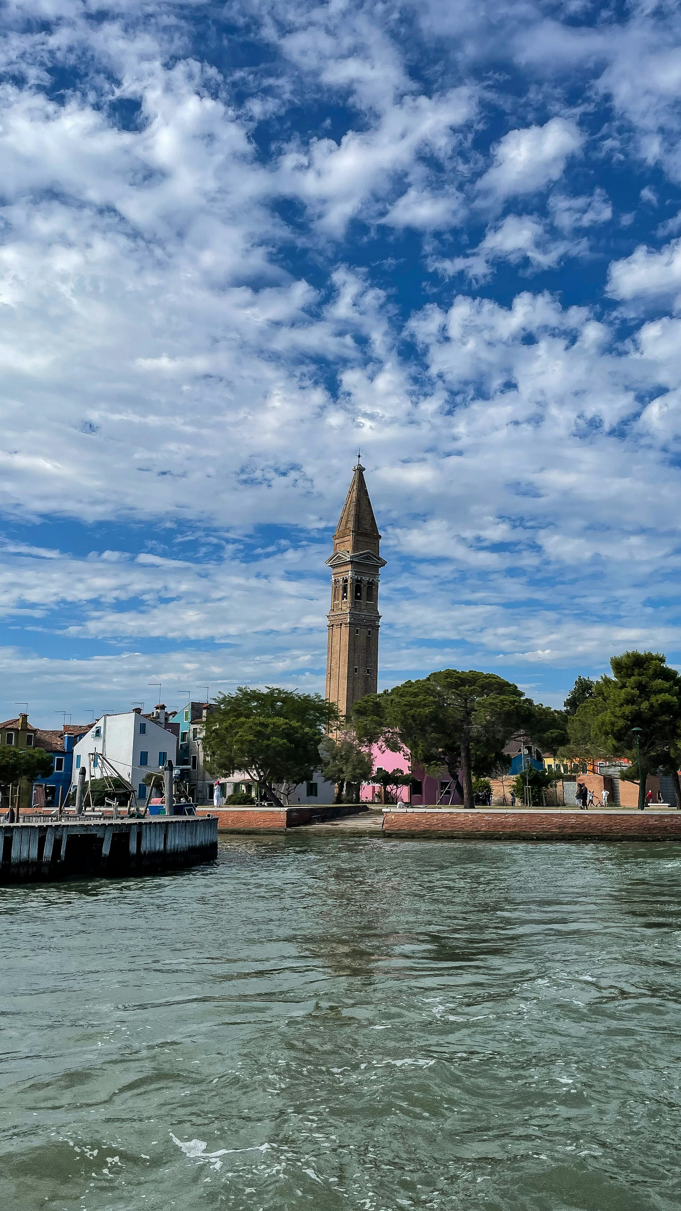 a boat traveling down a river next to a tall tower