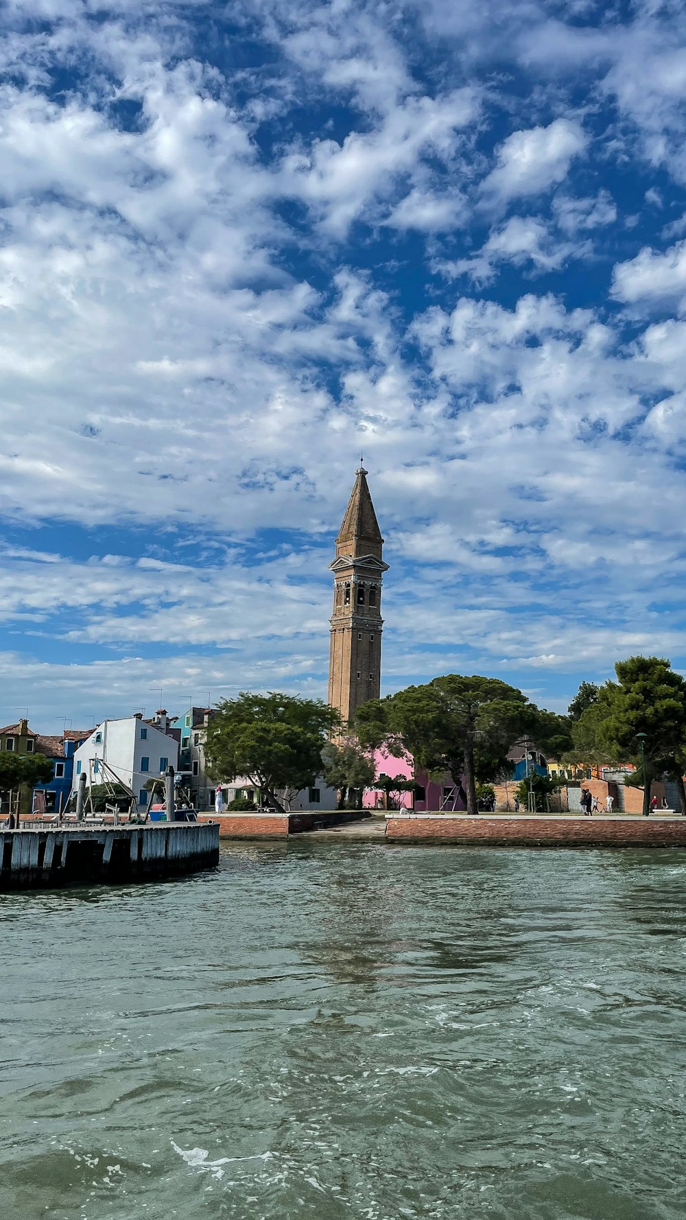 a boat traveling down a river next to a tall tower