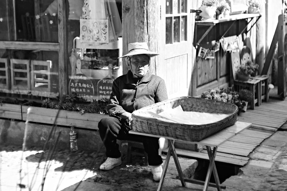 a black and white photo of a man sitting on a bench