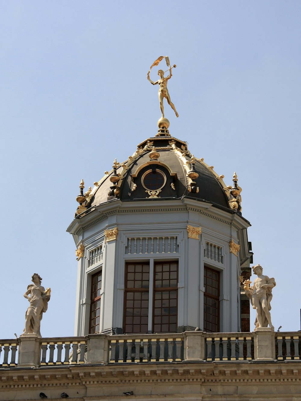 a clock tower with statues on top of it