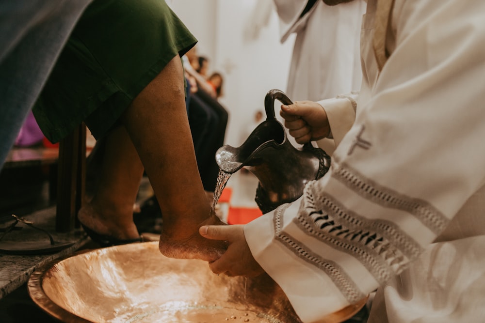 a close up of a person pouring something into a bowl