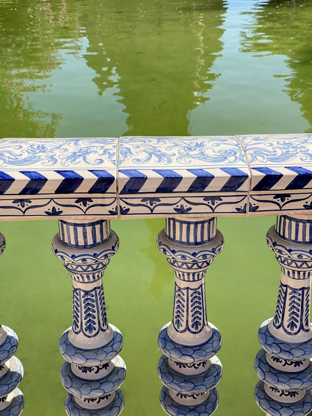 a close up of a blue and white fence with water in the background