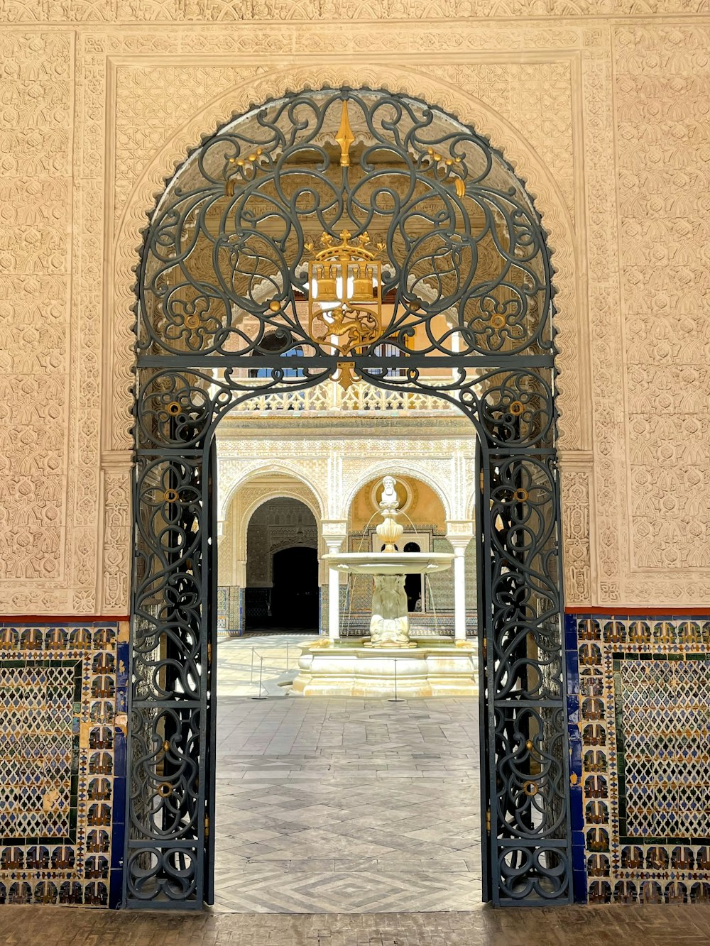 a large metal gate with a chandelier above it