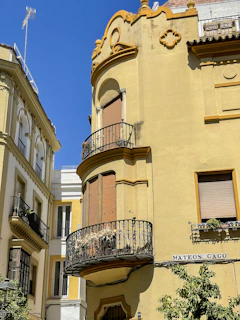 a yellow building with a balcony and balconies