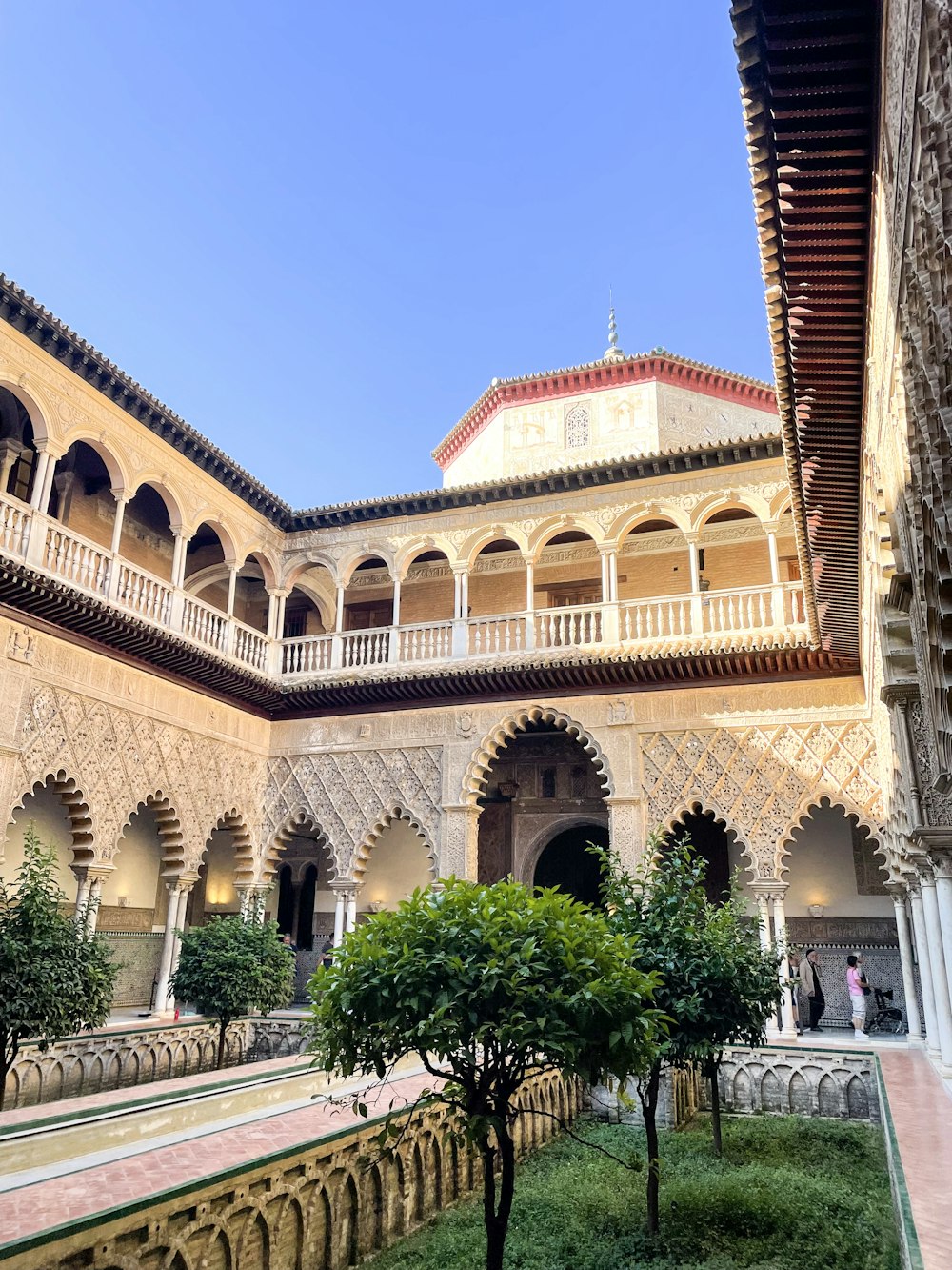 a courtyard of a building with a clock tower in the background