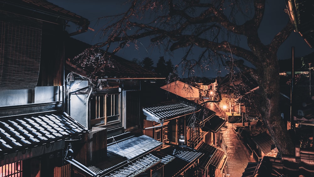 a dark alley at night with a tree in the foreground