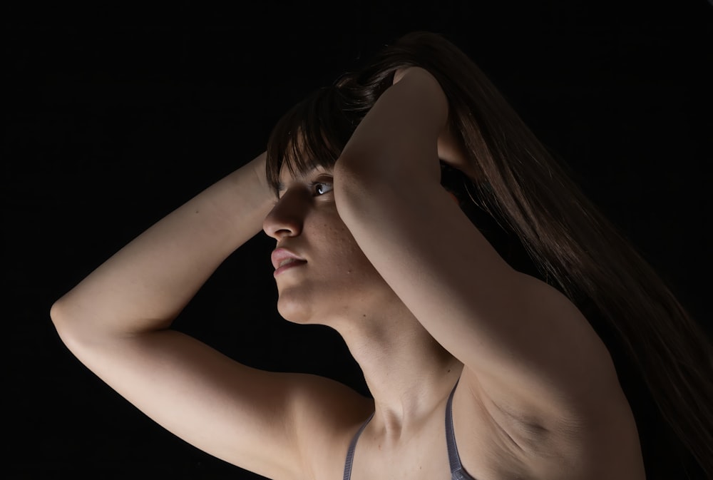 a woman in a bra top is holding her hair