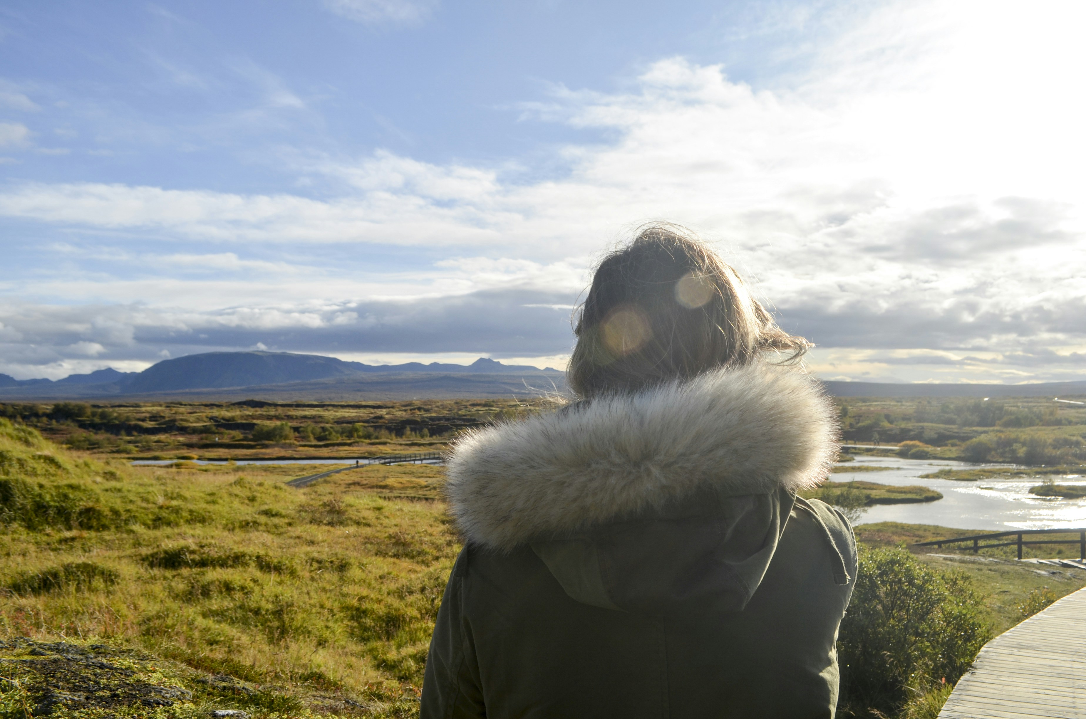 a woman in a parka looking out over a field