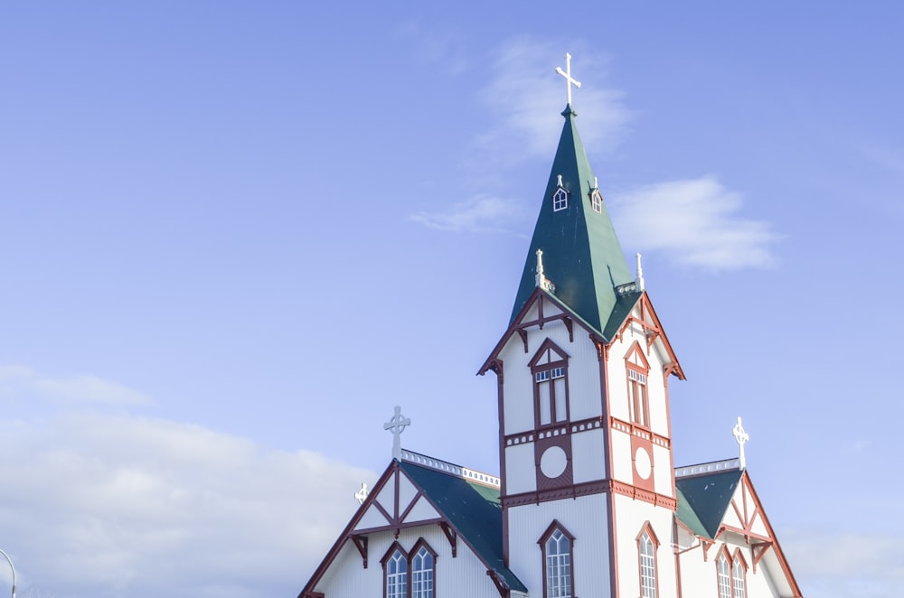 a white and red church with a green steeple