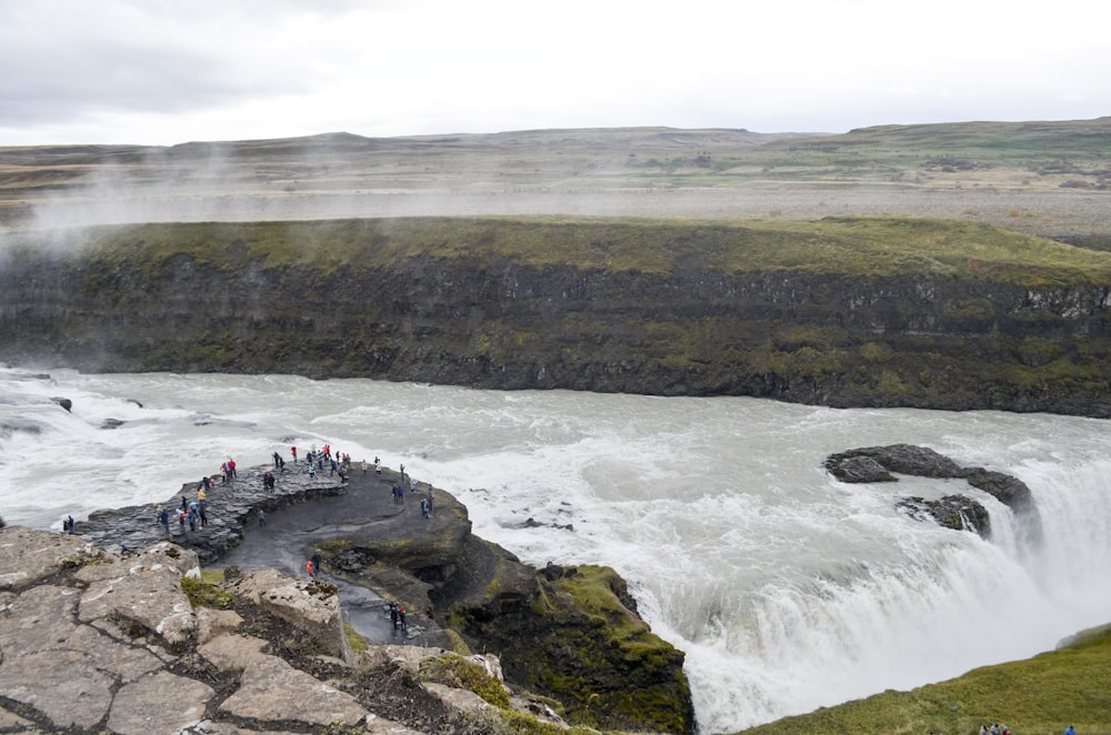 a group of people standing at the edge of a waterfall