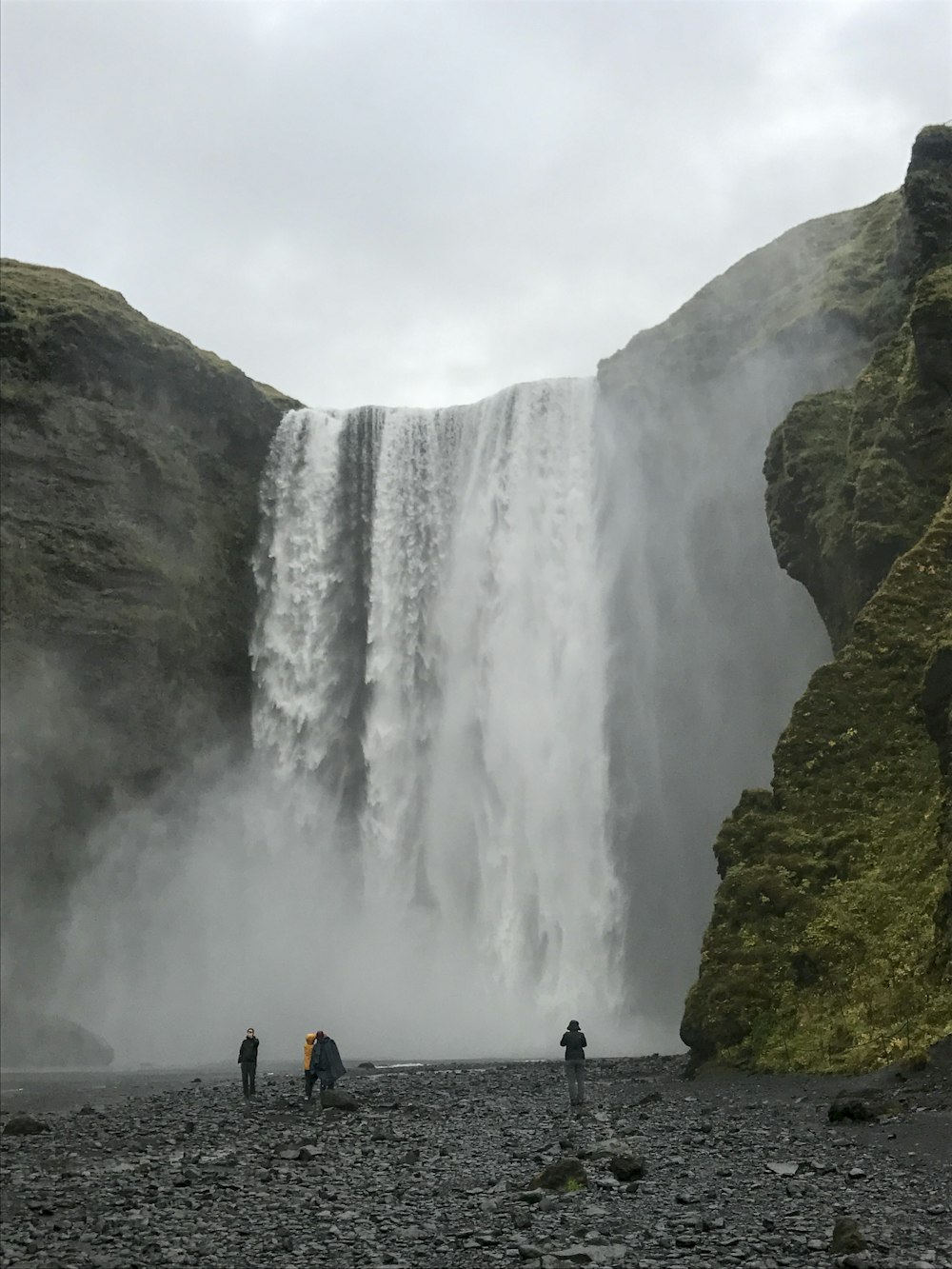 a group of people standing in front of a waterfall