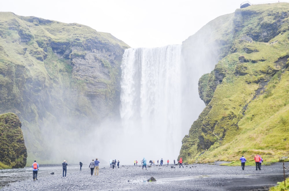 a group of people standing in front of a waterfall