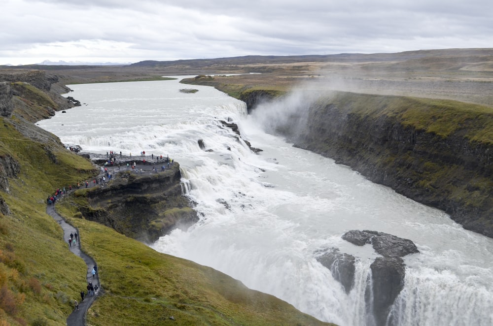 a group of people standing on the side of a waterfall