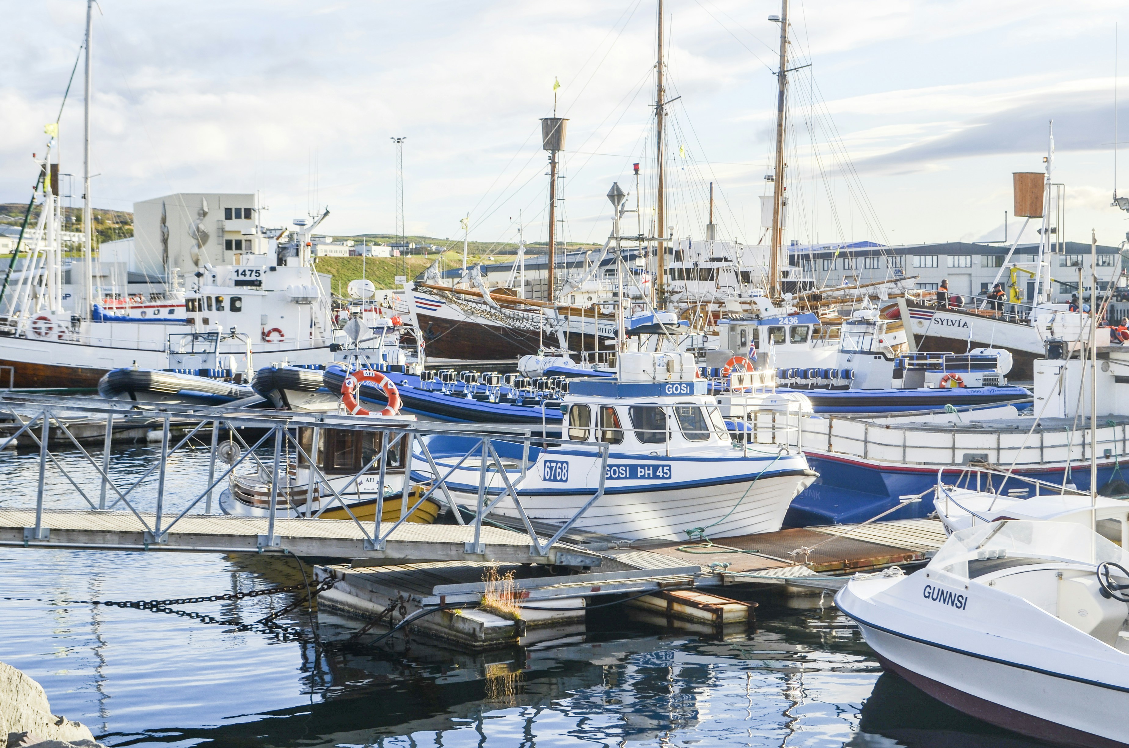 a harbor filled with lots of boats next to a pier
