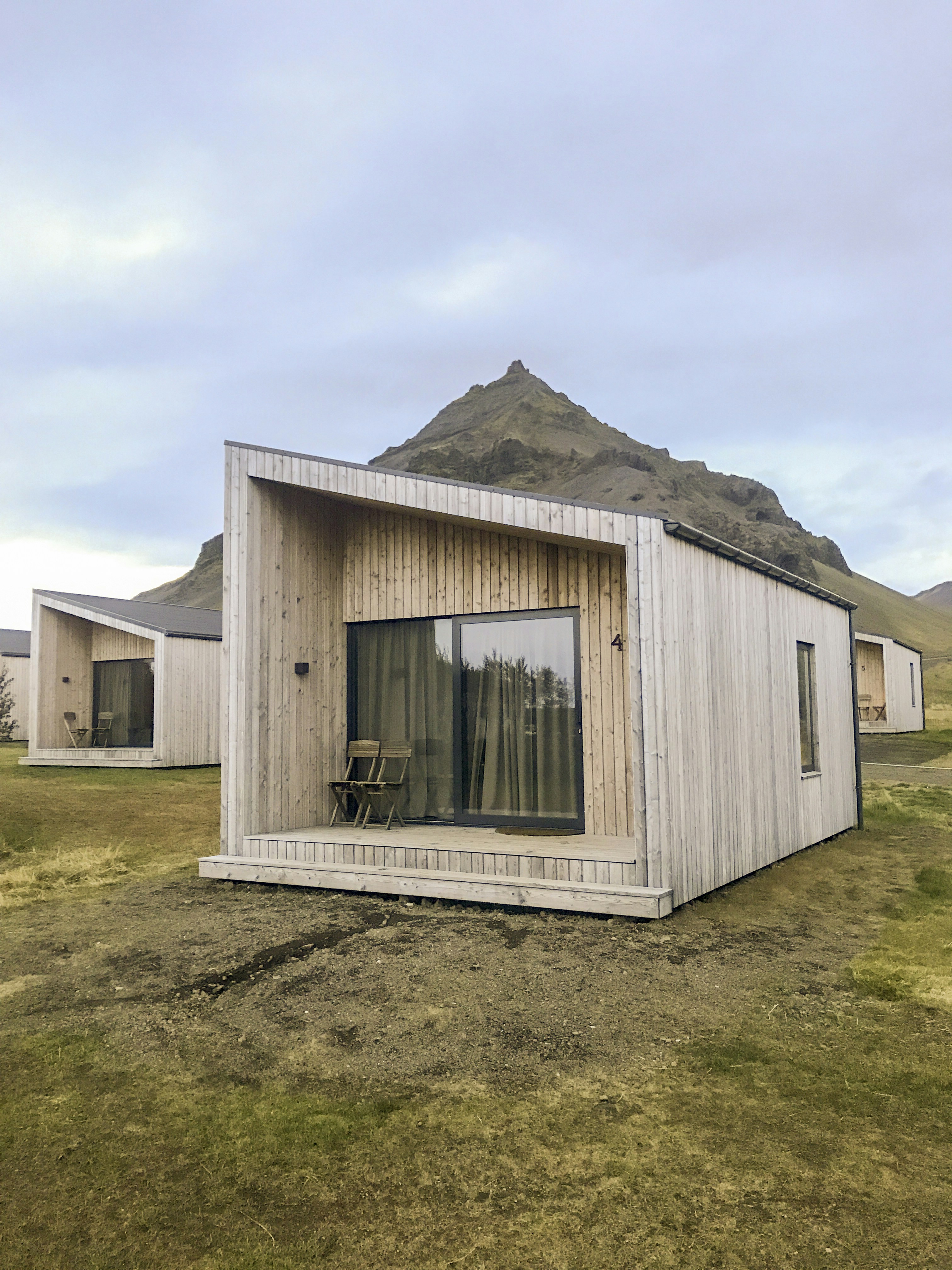 a small wooden building sitting on top of a grass covered field