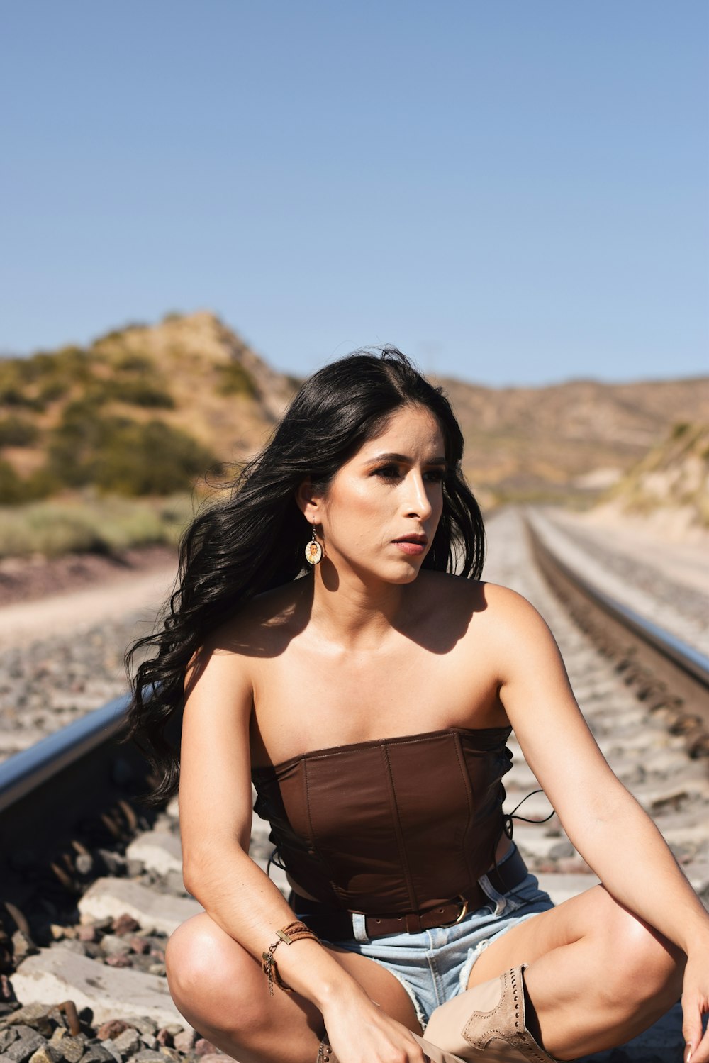 a woman is sitting on a train track