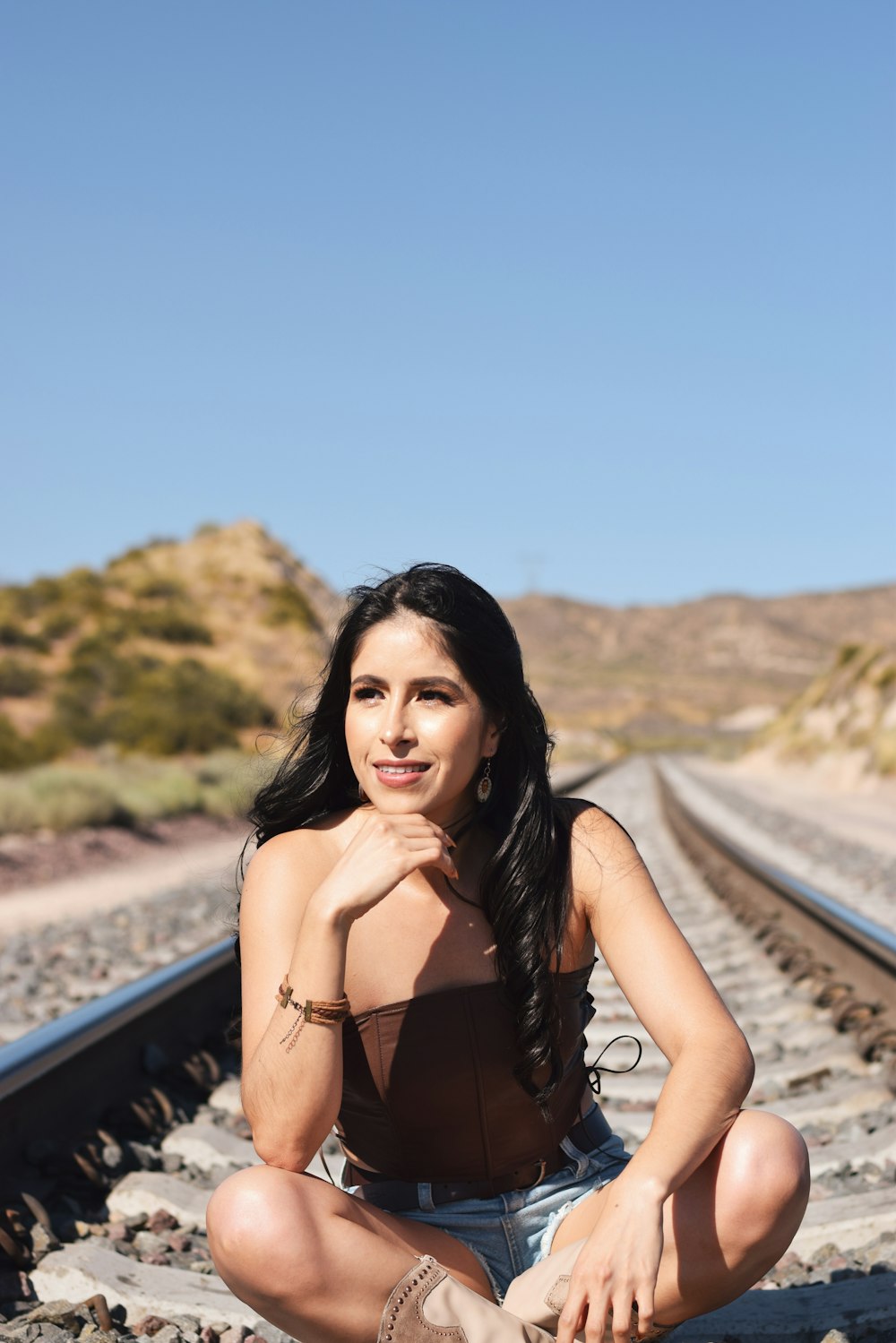 a woman sitting on a train track posing for a picture