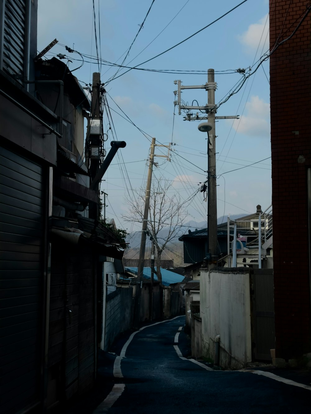 a narrow street with power lines above it