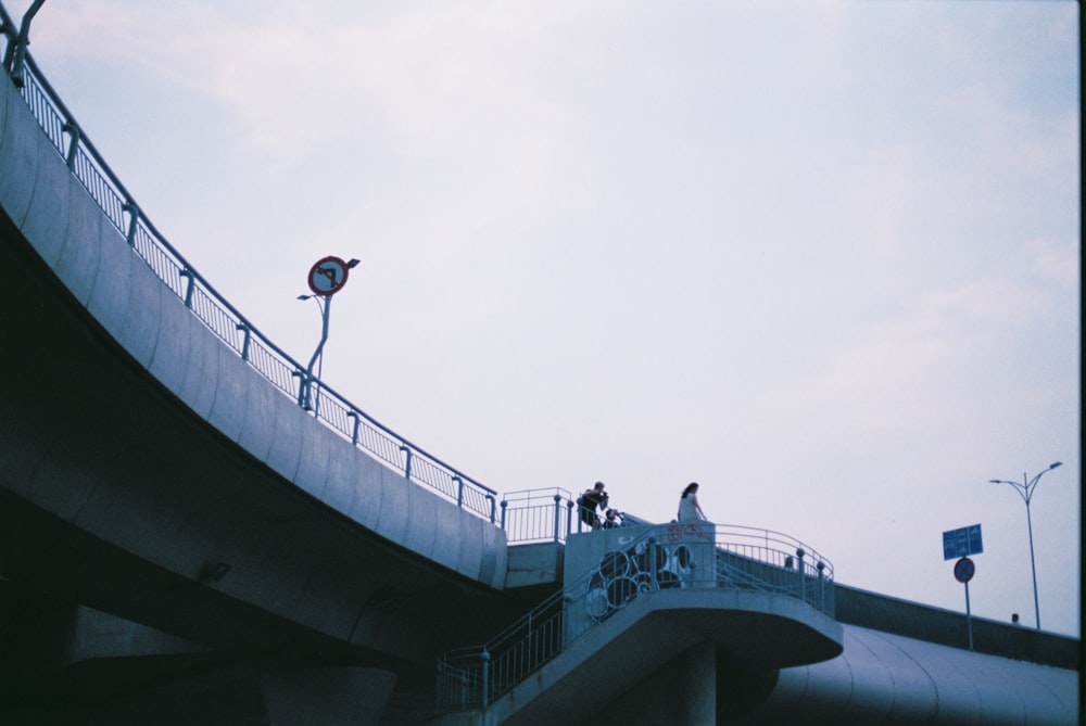 a couple of people standing on top of a bridge