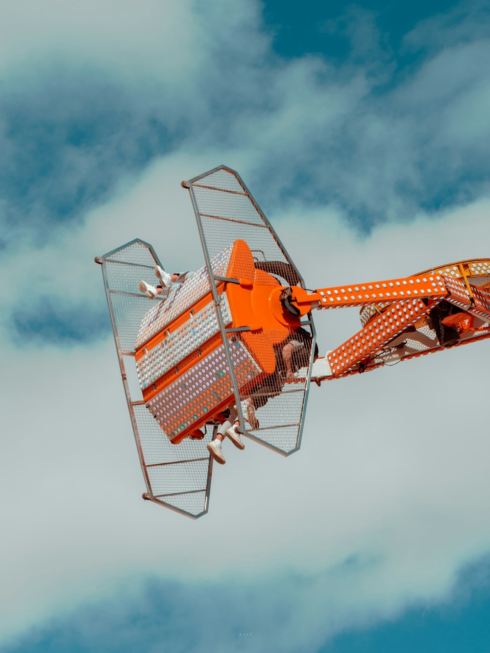 a carnival ride in the middle of a cloudy sky