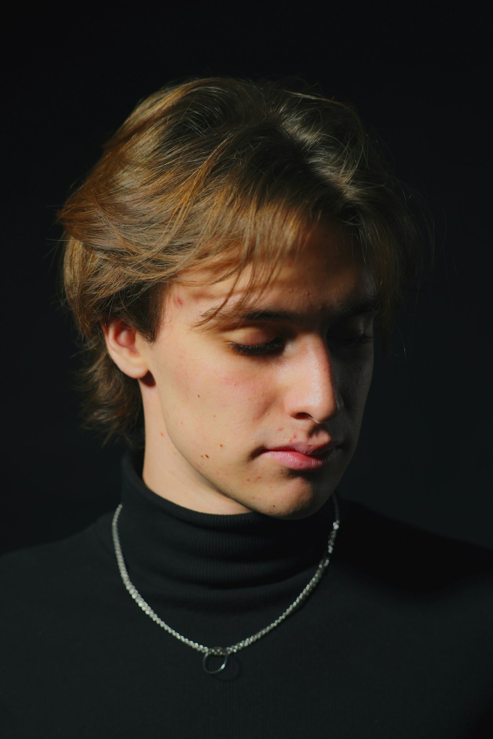 a young man wearing a black turtle neck sweater