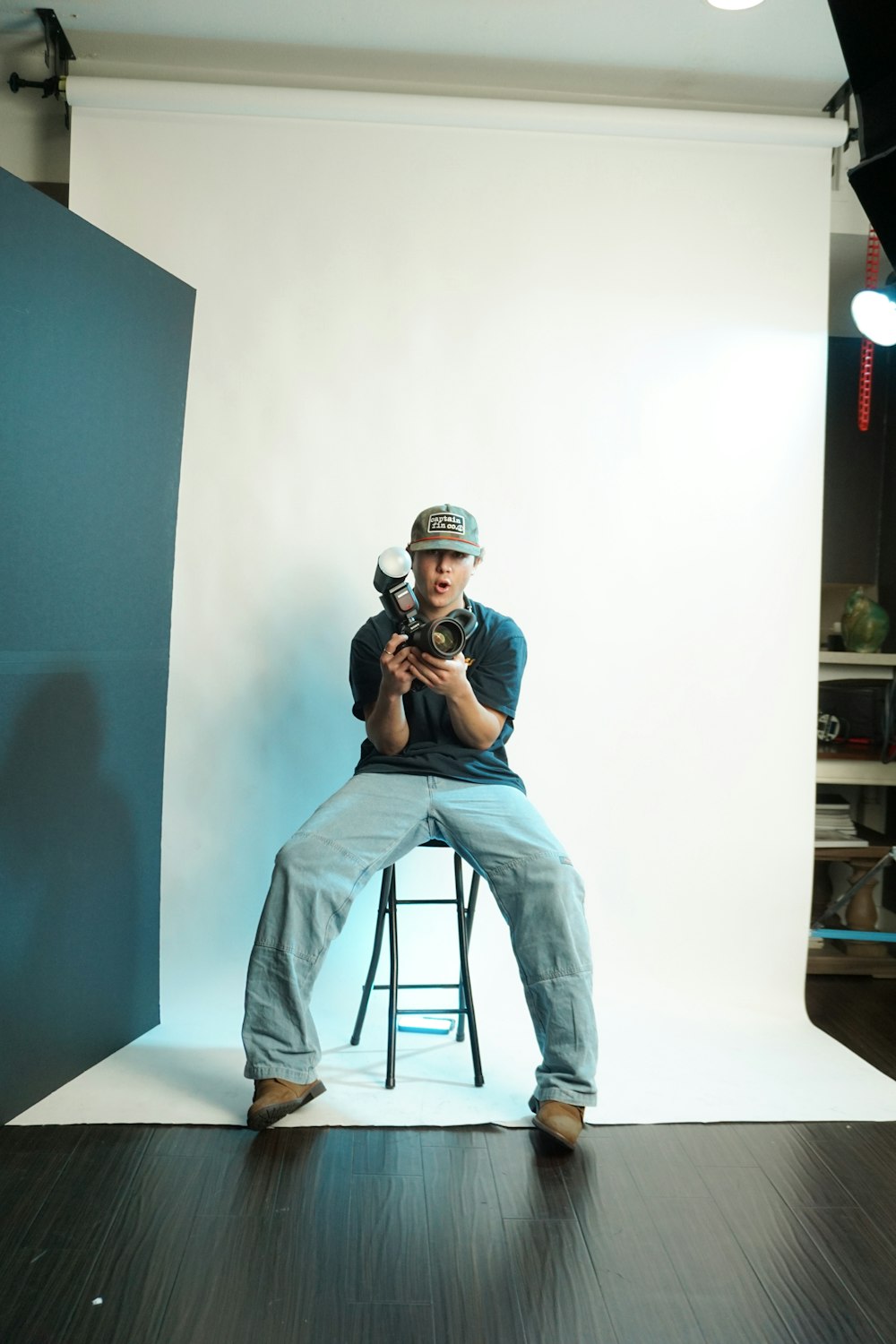 a man sitting on a stool holding a camera