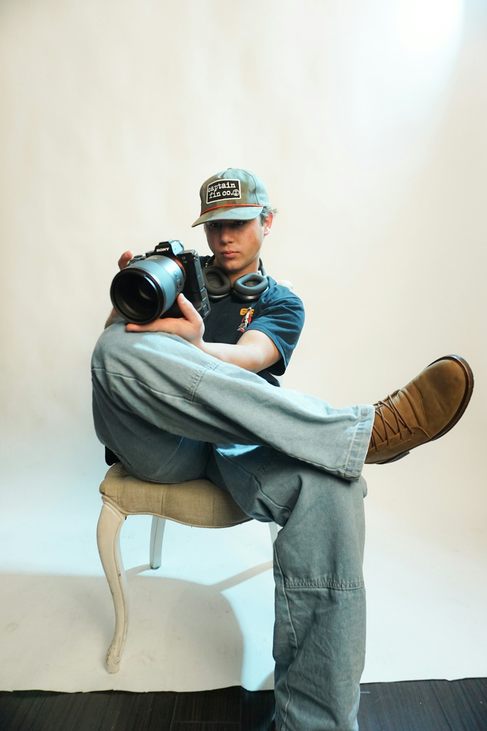 a man sitting on a chair holding a camera