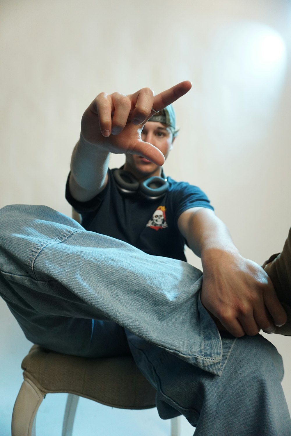 a man sitting on a stool making a peace sign