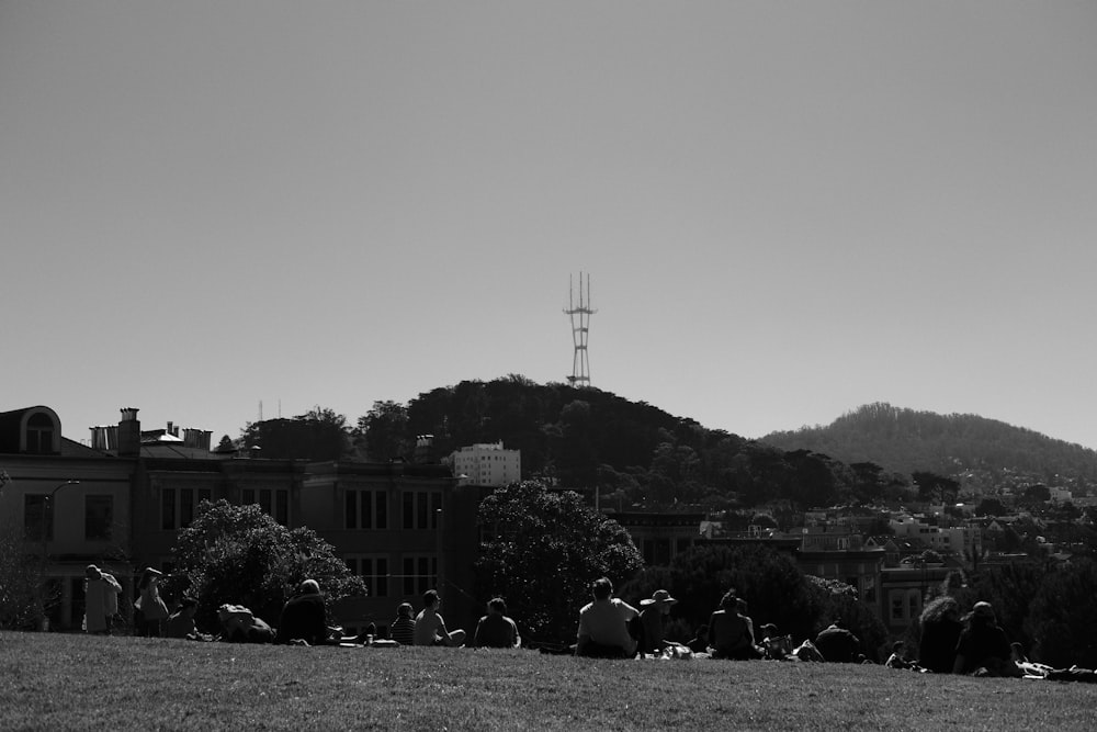 a group of people sitting on top of a lush green field