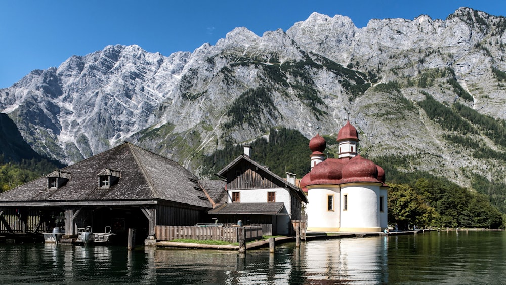 a church on a lake with mountains in the background