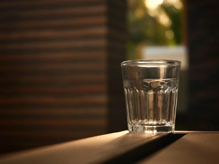 A glass of water on a wooden table in soft morning light