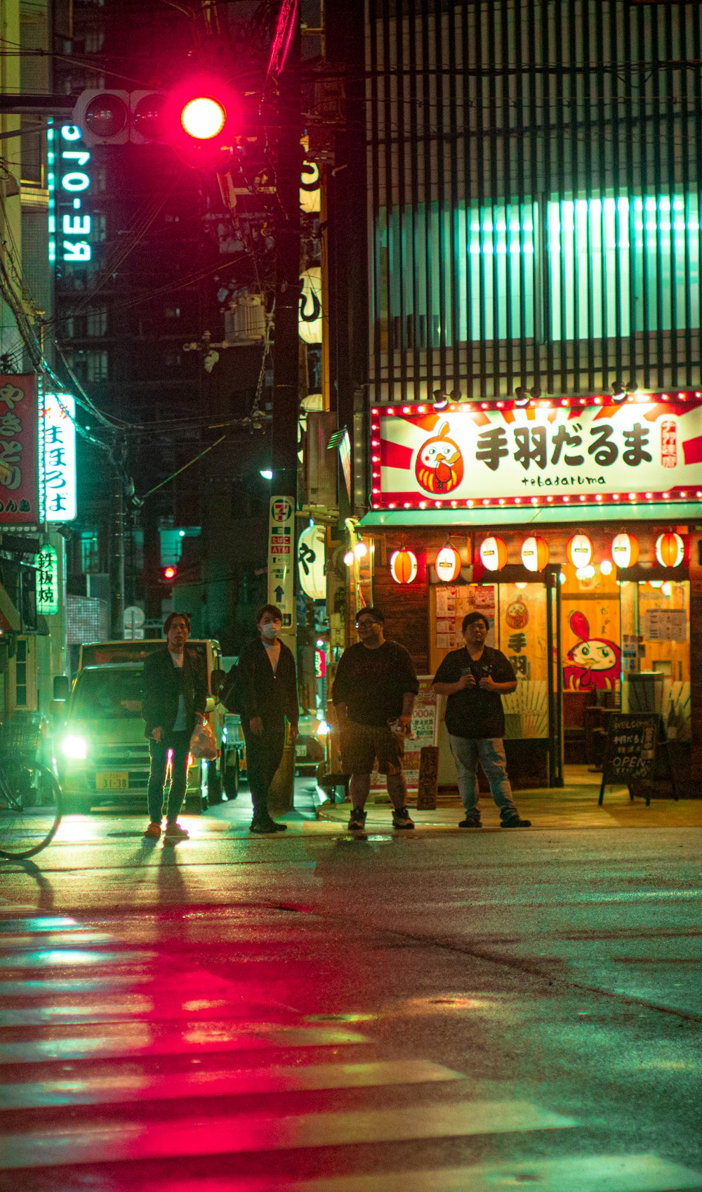 a group of people crossing a street at night