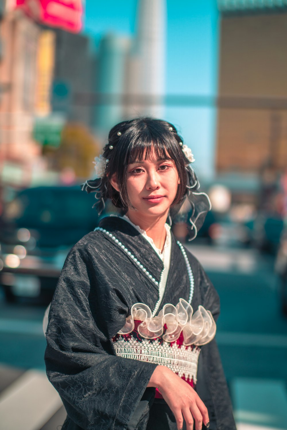 a woman in a kimono standing on a street corner