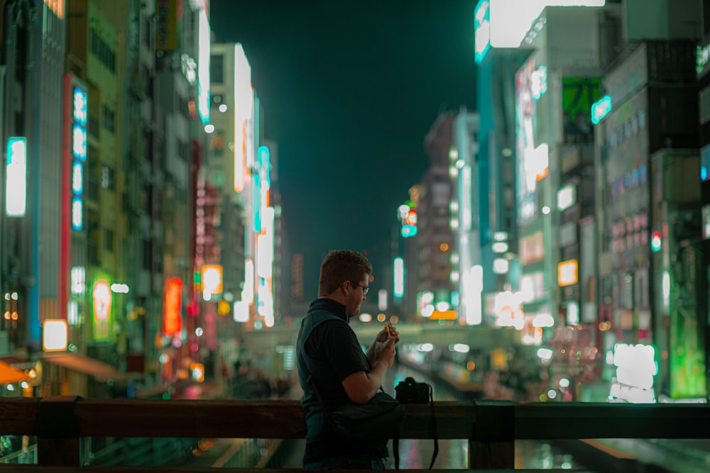 a man sitting on a bench looking at his cell phone