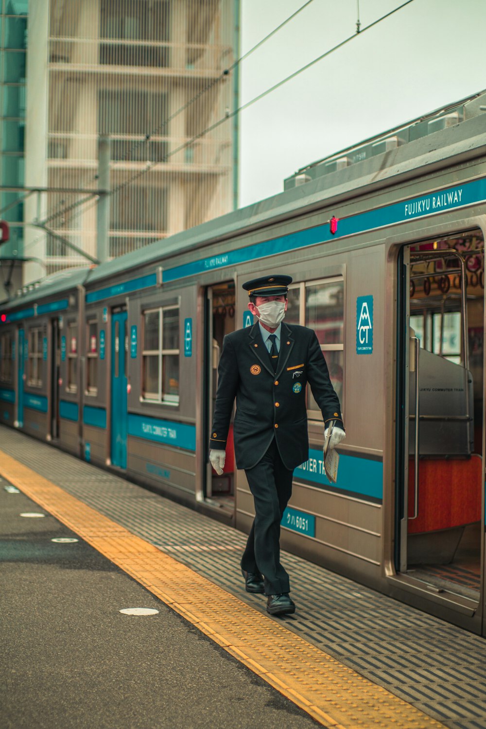 a man in a suit and tie walking on a platform next to a train