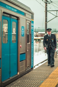 a man in a uniform walking next to a train