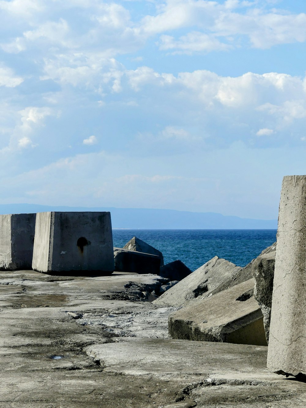 a concrete block sitting on top of a beach next to the ocean