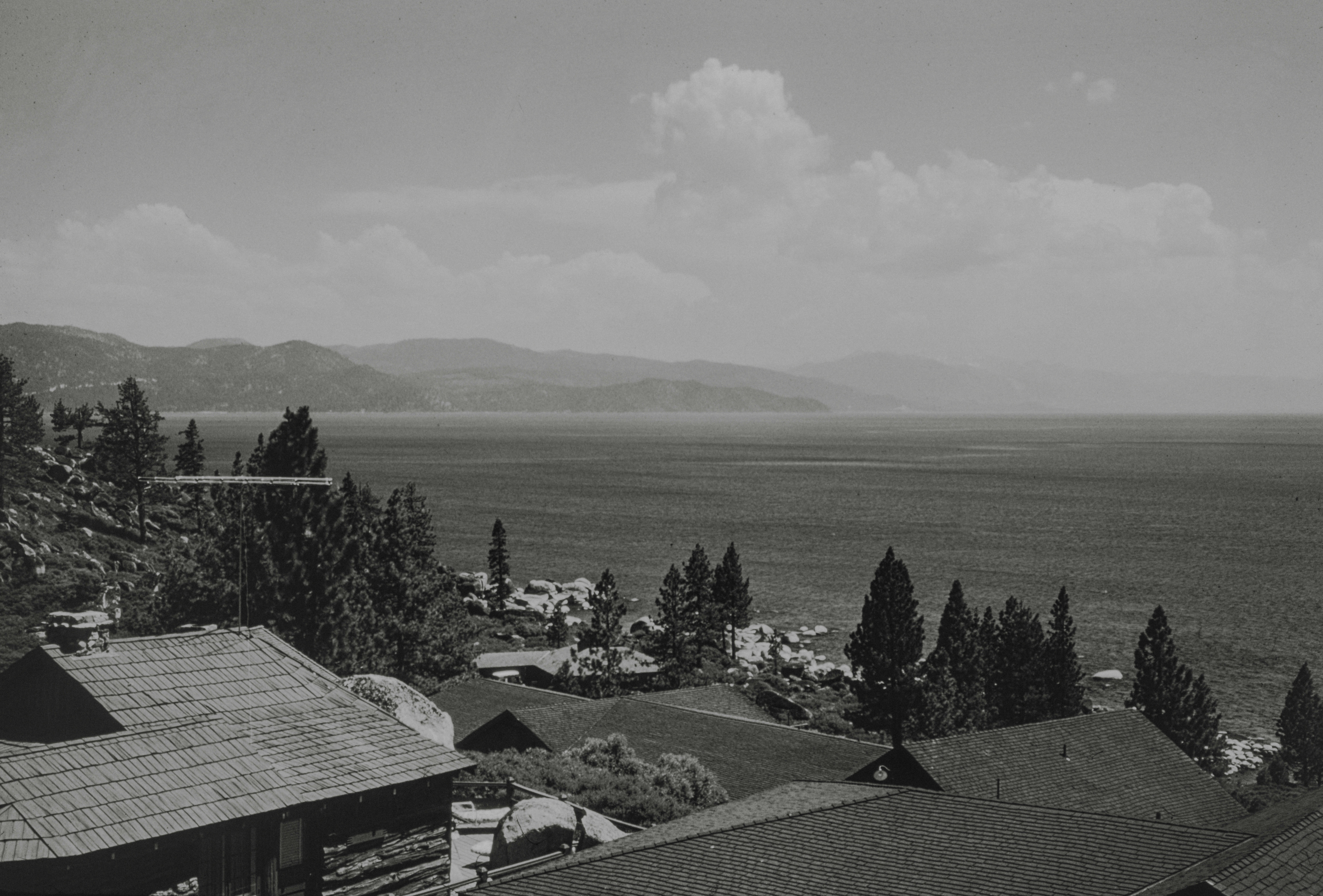 a black and white photo of a town with mountains in the background, Lake Tahoe seen from Cal-Neva Lodge, Crystal Bay. 1961