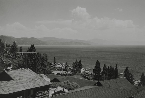 A black and white photo of a town with mountains in the background — Lake Tahoe, United States