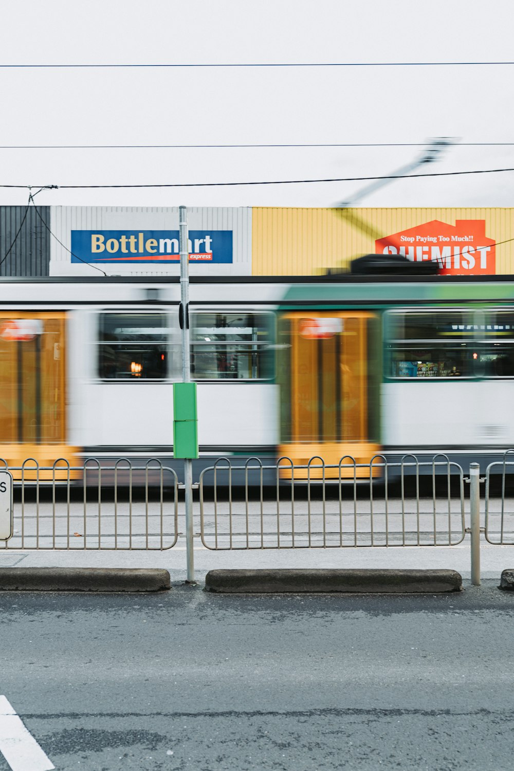 a train traveling past a train station next to a street