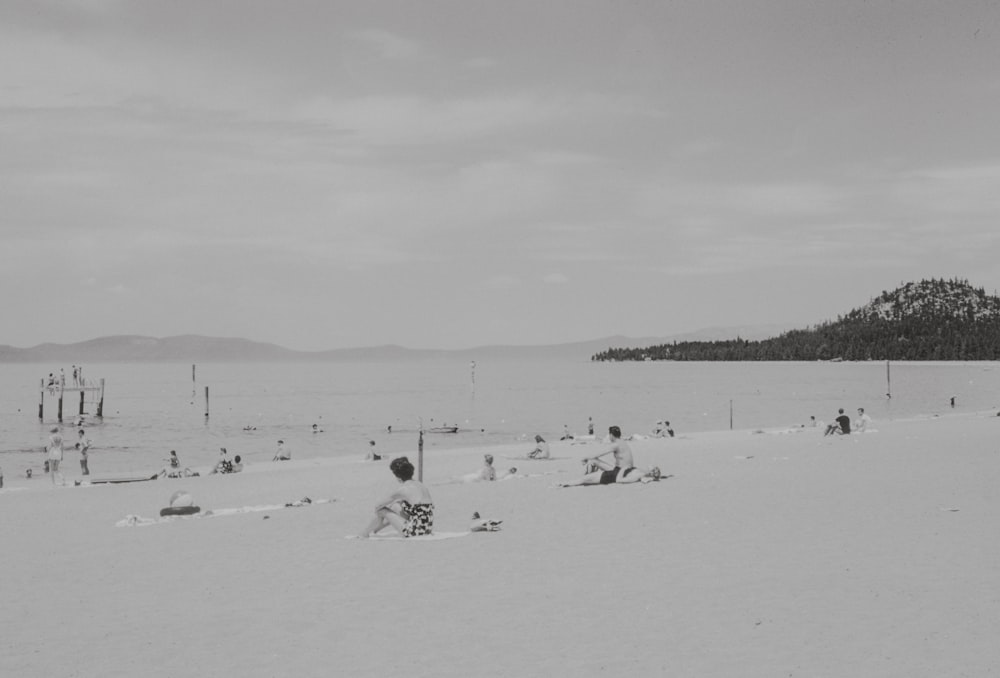 a black and white photo of people on a beach