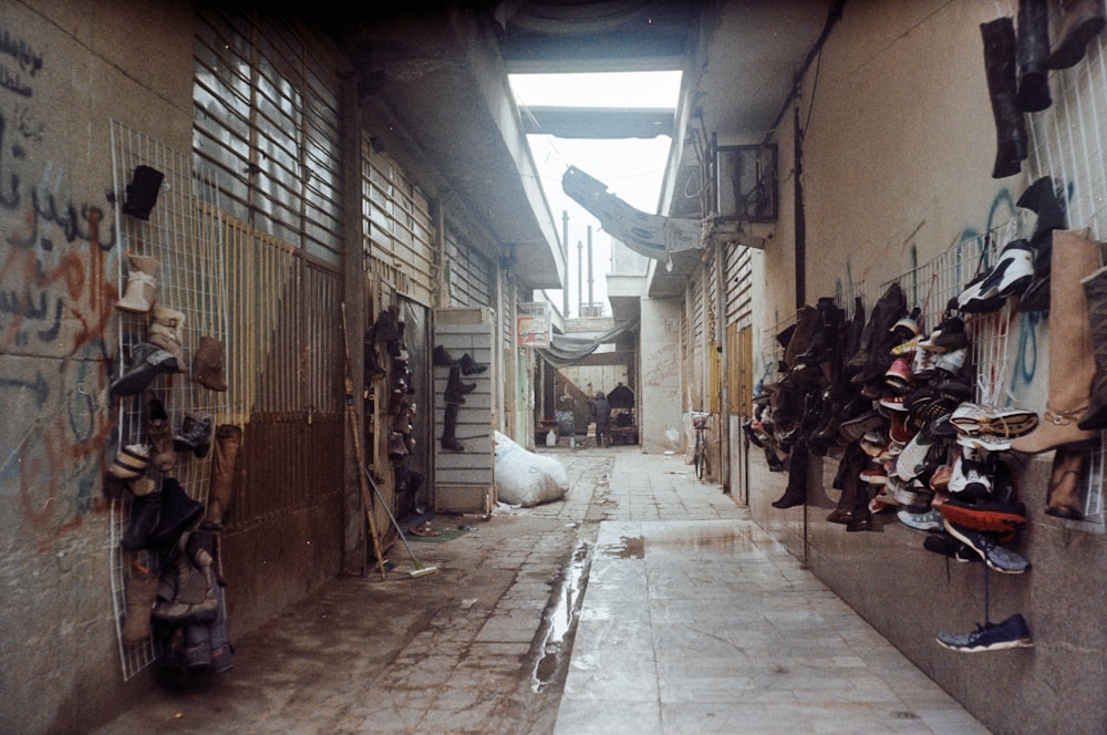 a narrow alley way with a bunch of shoes hanging on the wall