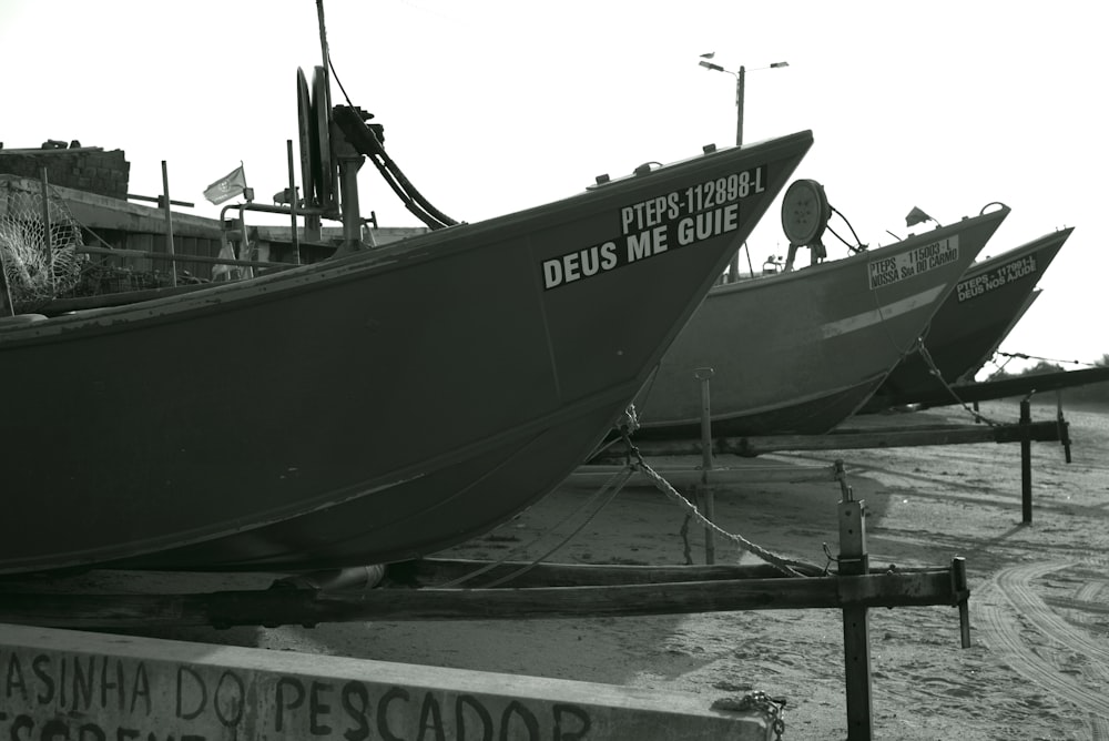 a couple of boats sitting on top of a sandy beach